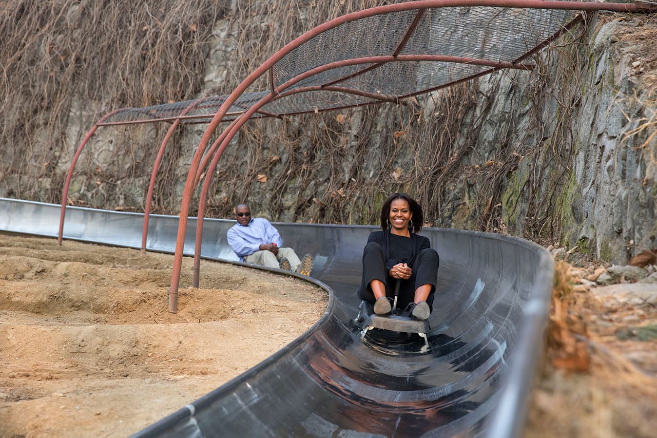 La primera dama Michelle Obama deslizándose por un tobogán en la Gran Muralla China, en Mutianyu, China, en su visita el 23 de marzo de 2014.