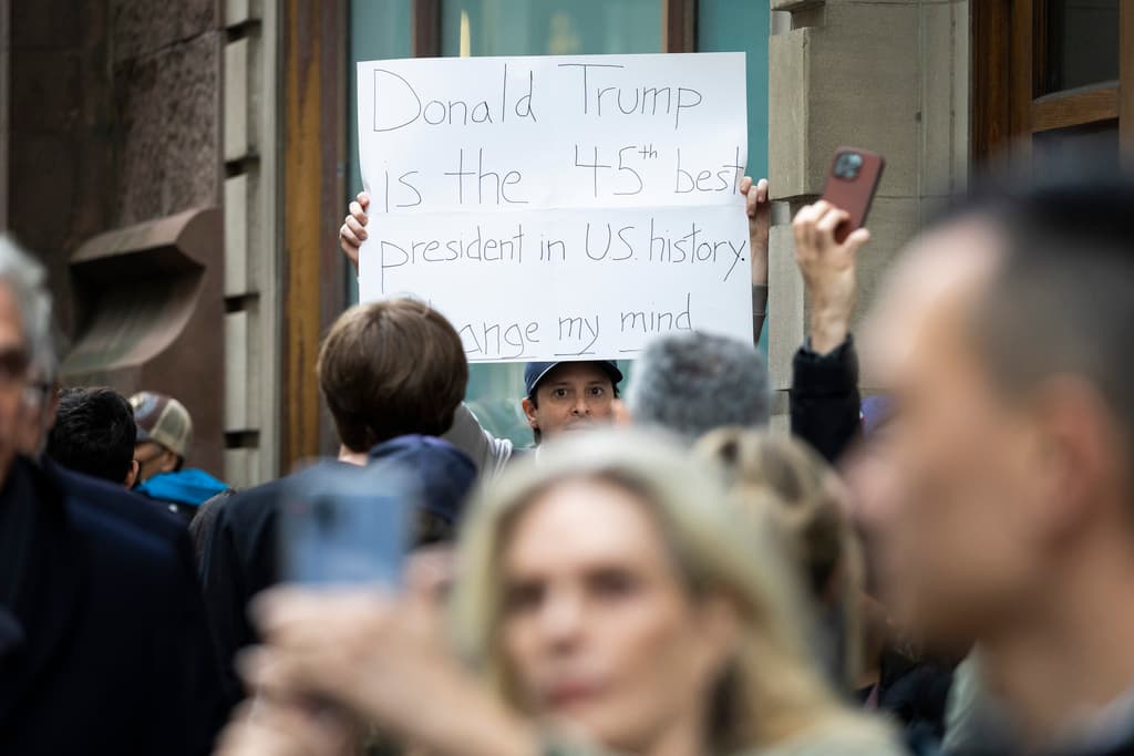 Un seguidor del expresidente frente a la Torre Trump con una pancarta expresando su apoyo. Una eventual 
<b><a href="https://www.univision.com/noticias/politica/candidato-imputado-trump-puede-aspirar-presidencia-acusacion-criminal">condena no podría impedir que Trump se presentara</a></b> o que ejerciera el cargo, en caso de ganar la presidencia en 2024.