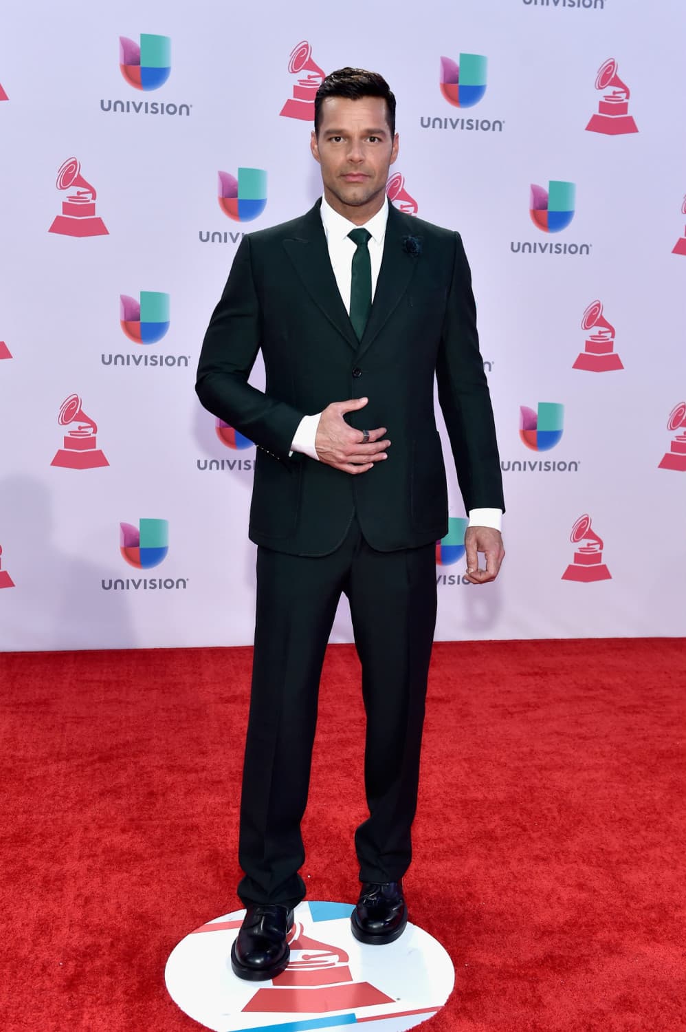 Ricky Martin. Pareciera que los años no pasan en vano para el galán boricua. Su traje y corbata negra con camisa blanca se acompañan de una evidente sesión de grooming y peinado relamido hacia atrás.