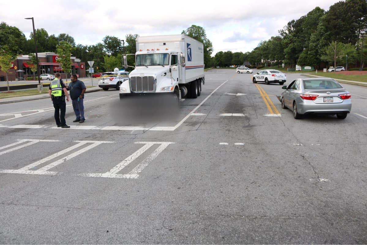 Motociclista muere después de chocar contra un automóvil y deslizarse frente a un camión de correo en Norcross