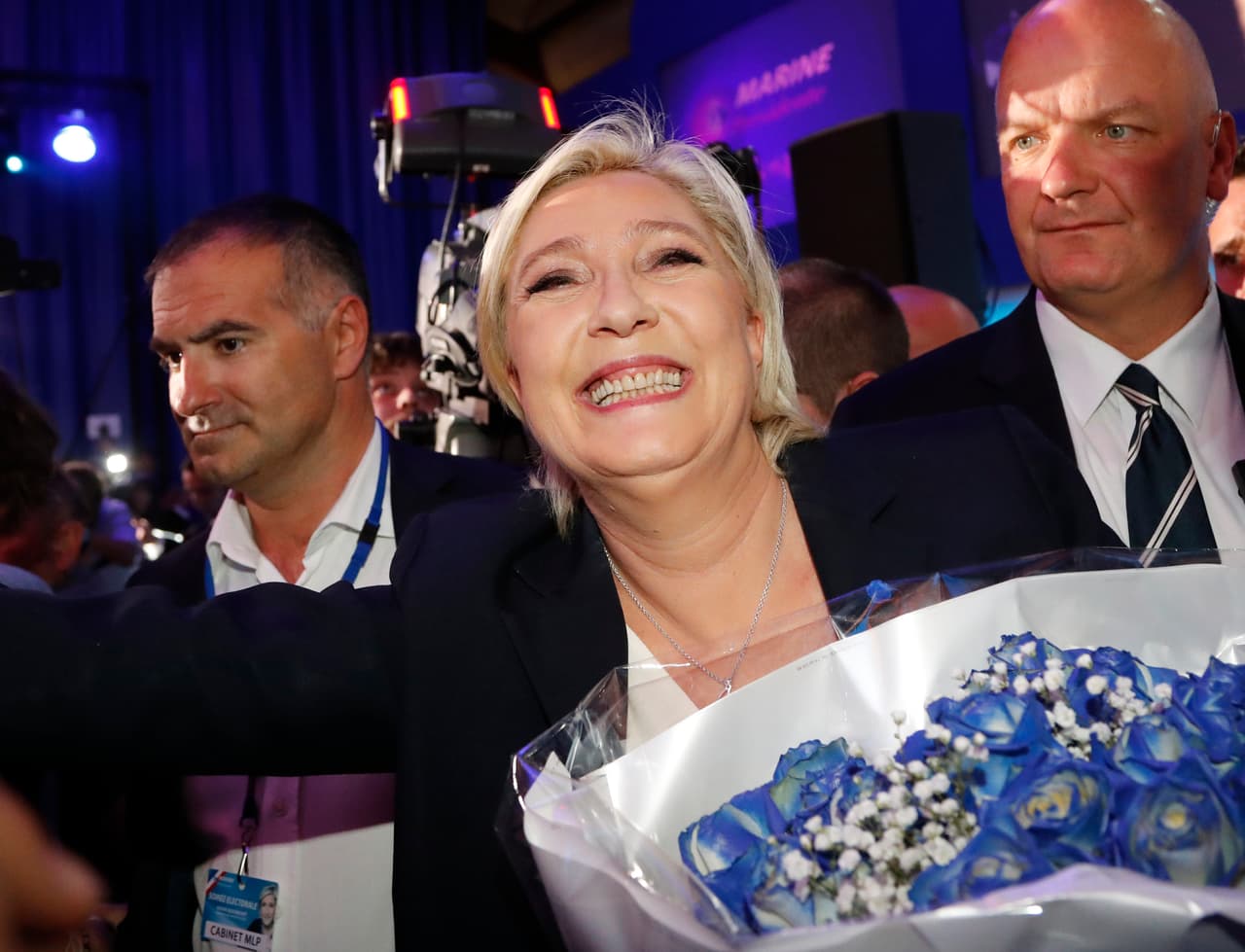 Marine Le Pen recibe flores de sus seguidores y sonríe tras el resultado de las elecciones que le da el pase a segunda vuelta.