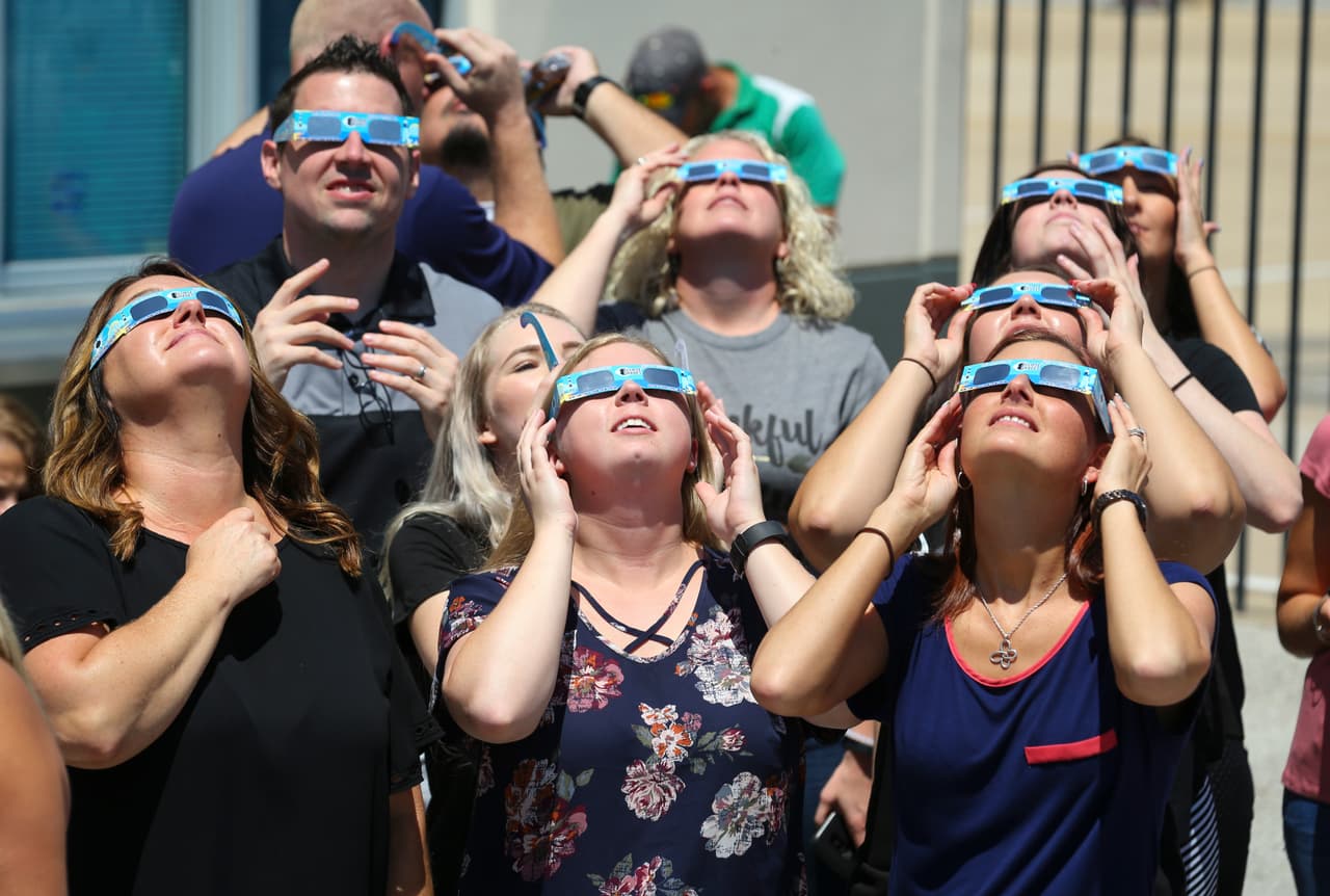 <b>Con lentes especiales</b>: En Fort Worth, Texas, grupos de personas se reunieron en el circuito de carros de carreras Texas Motor Speedway para ver el eclipse. El grupo de la foto utilizó lentes especiales para proteger los ojos de los intensos rayos solares. Richard Rodriguez/Getty Images