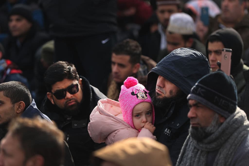 Un hombre sostiene a su hija mientras ora en la manifestación de este viernes en el terminal 4 del aeropuerto JFK.