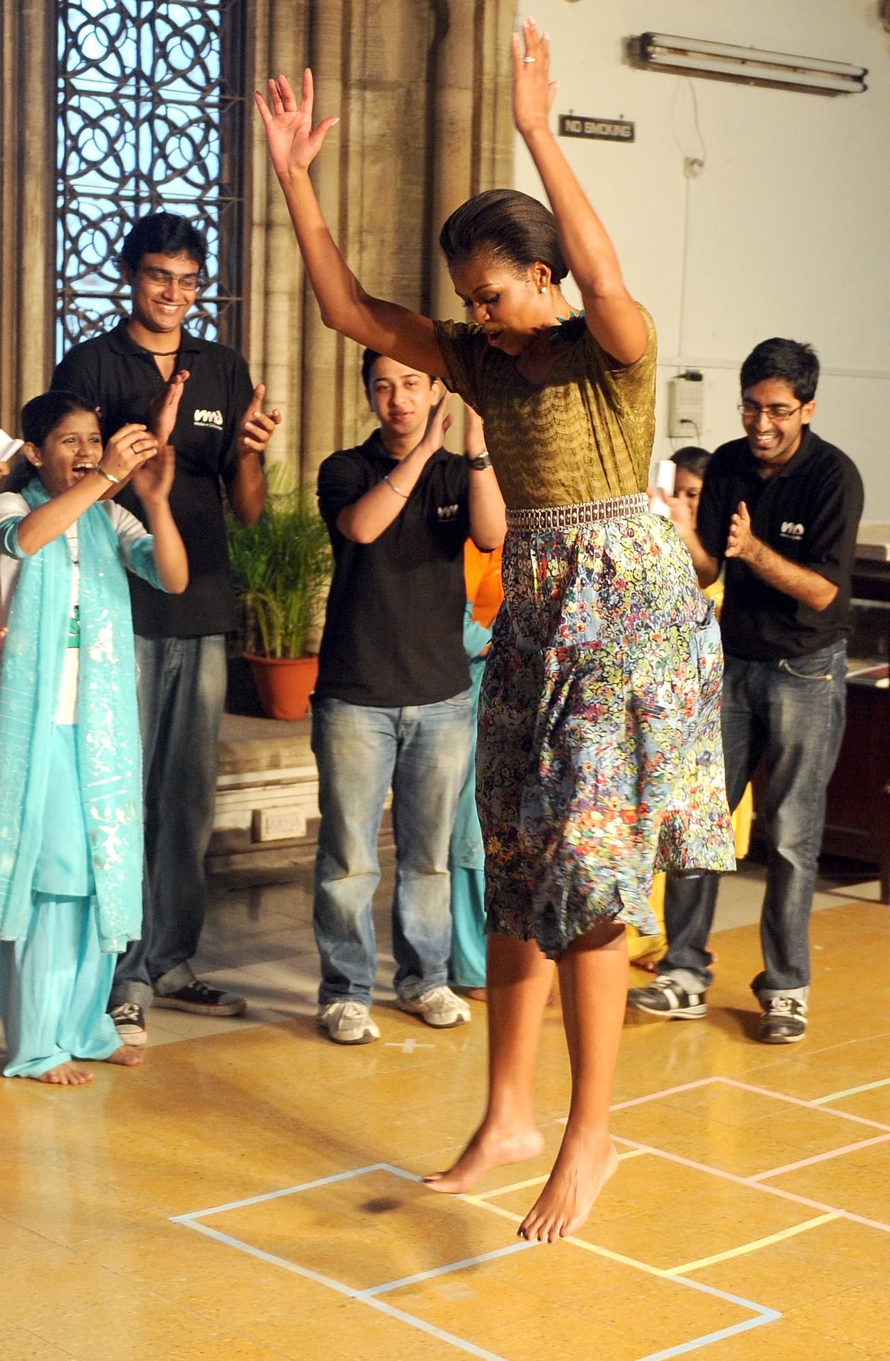 Si su rostro fue siempre muy expresivo, lo mismo sucedía con su cuerpo. Aquí, Michelle Obama juega a la rayuela en el campus de la universidad de Mumbay en su viaje en 2010. Michelle siempre se animó a compartir juegos con niños y niñas.
