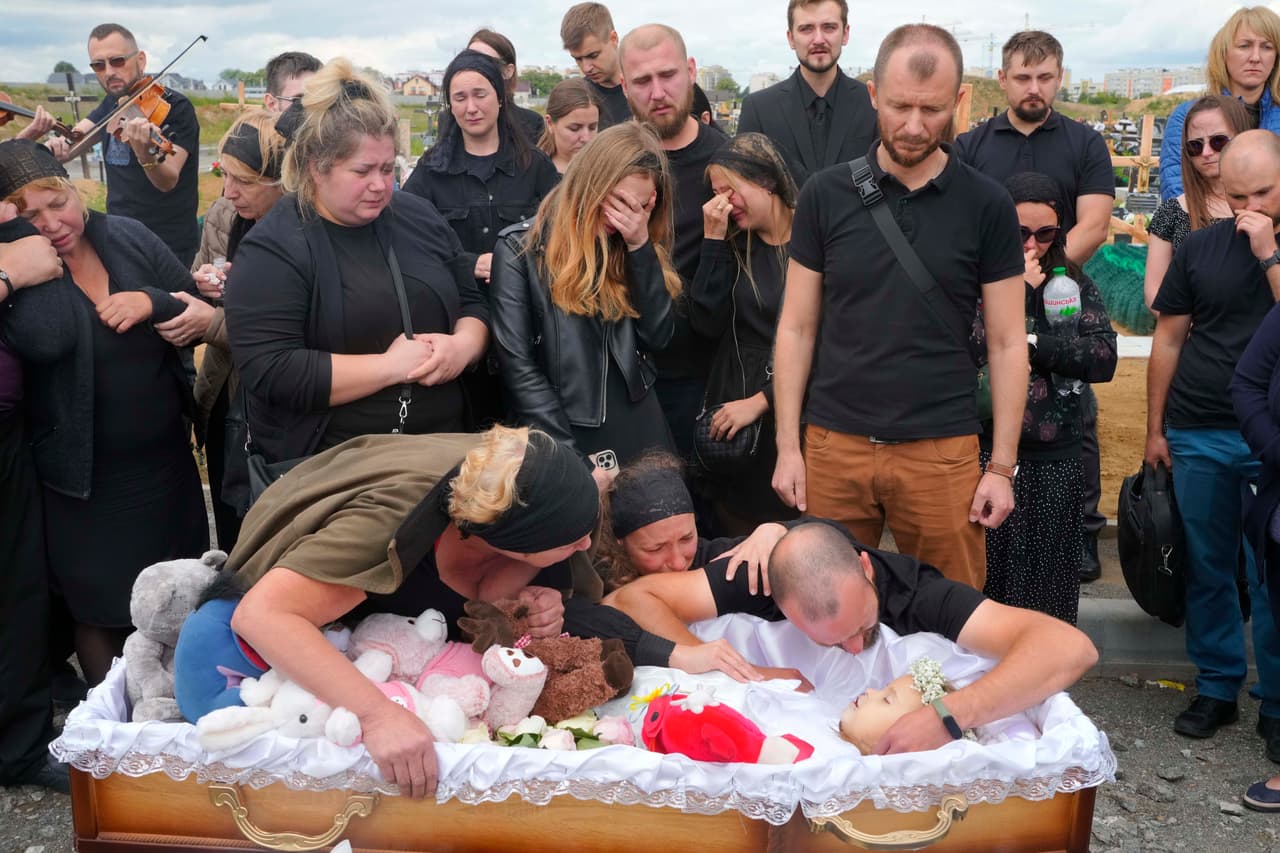 En la foto: 
<b>Familiares y amigos en el funeral de Liza, una niña de 4 años muerta por un ataque ruso, en Vinnytsia, Ucrania, el domingo 17 de julio de 2022. </b>Liza estaba entre las 23 personas muertas ese día, incluidos dos niños más de 7 y 8 años. Su madre, Iryna Dmytrieva, resultó herida. 
<br>
<br>
<br>