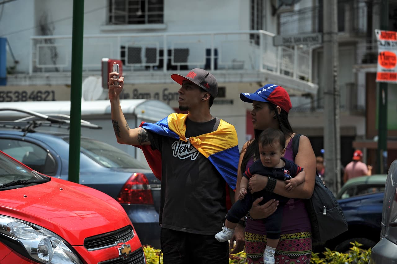 El informe de la OIM indica que en México hay 32,582 venezolanos registrados en 2017. En Panamá 36,365 y en Costa Rica 8,892. En la fotografía, inmigrantes venezolanos durante las protestas contra la Asamblea Nacional Constituyente -impuesta por el gobierno de Nicolás Maduro- en la Ciudad de México, en julio de 2017.
<br>