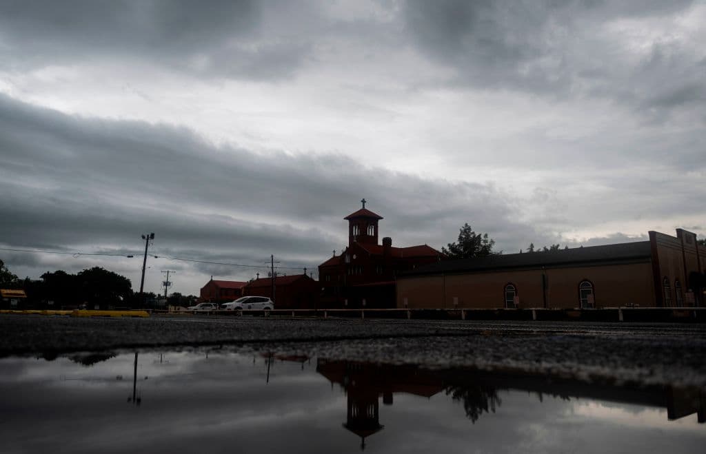 Una iglesia se refleja en un charco de agua cuando las bandas exteriores del huracán Laura pasan por la región de Lake Charles, Louisiana.