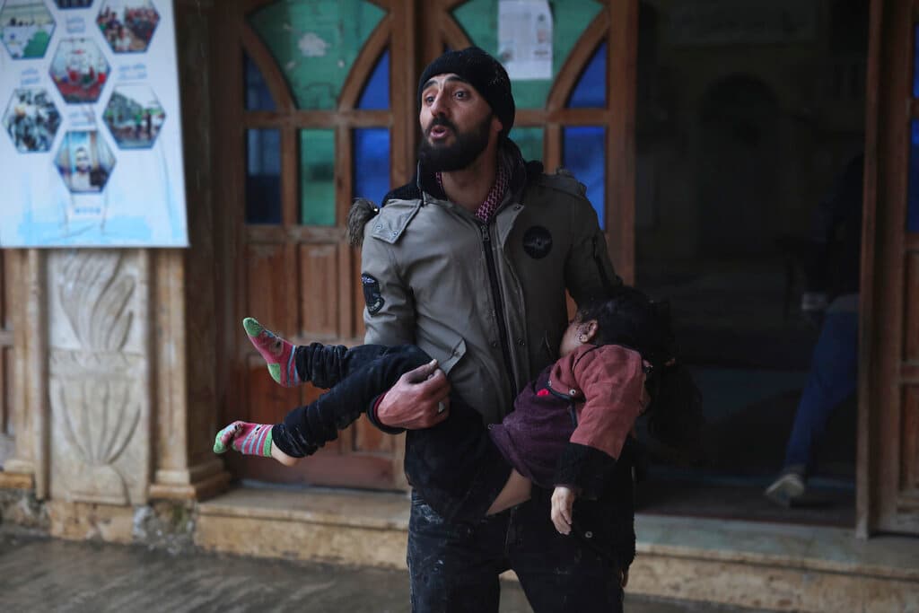 Un hombre sirio lleva a una niña muerta en la localidad de Azmarin, pequeña localidad rebelde siria en la provincia de Idlib, en las montañas junto a la frontera turca.