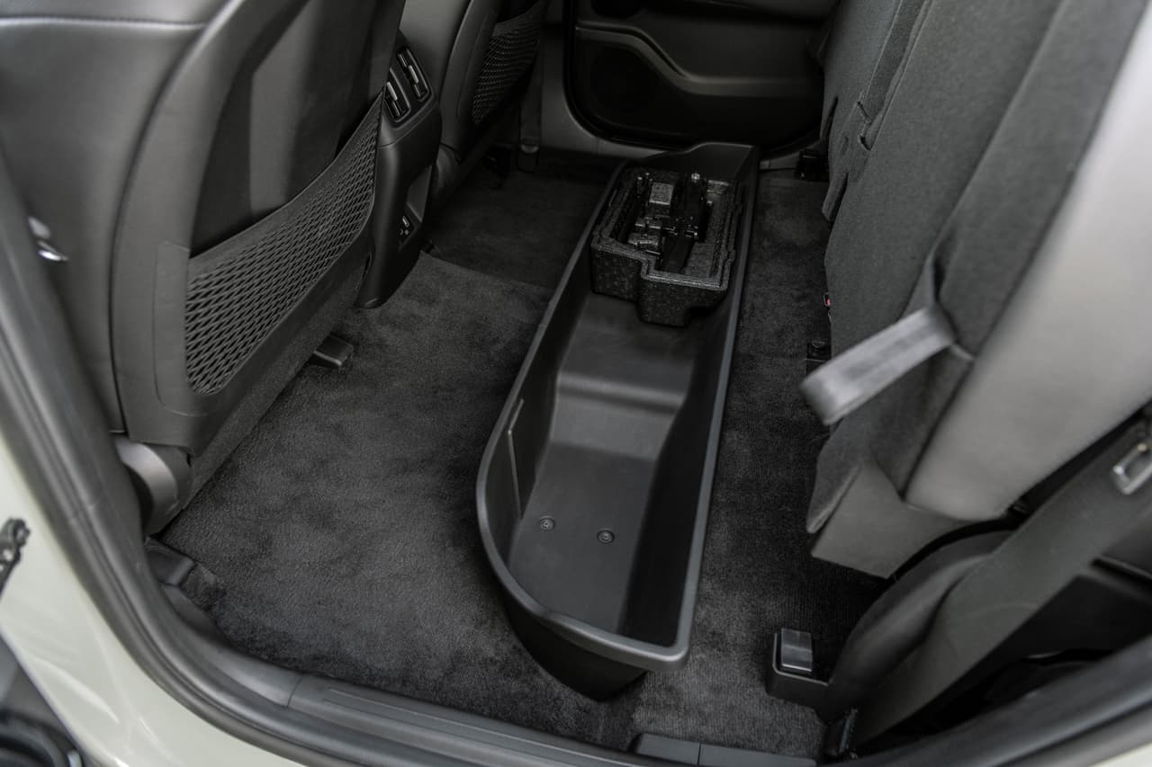 ... e incluso cuenta con convenientes espacios de almacenamiento debajo de la segunda fila de asientos.