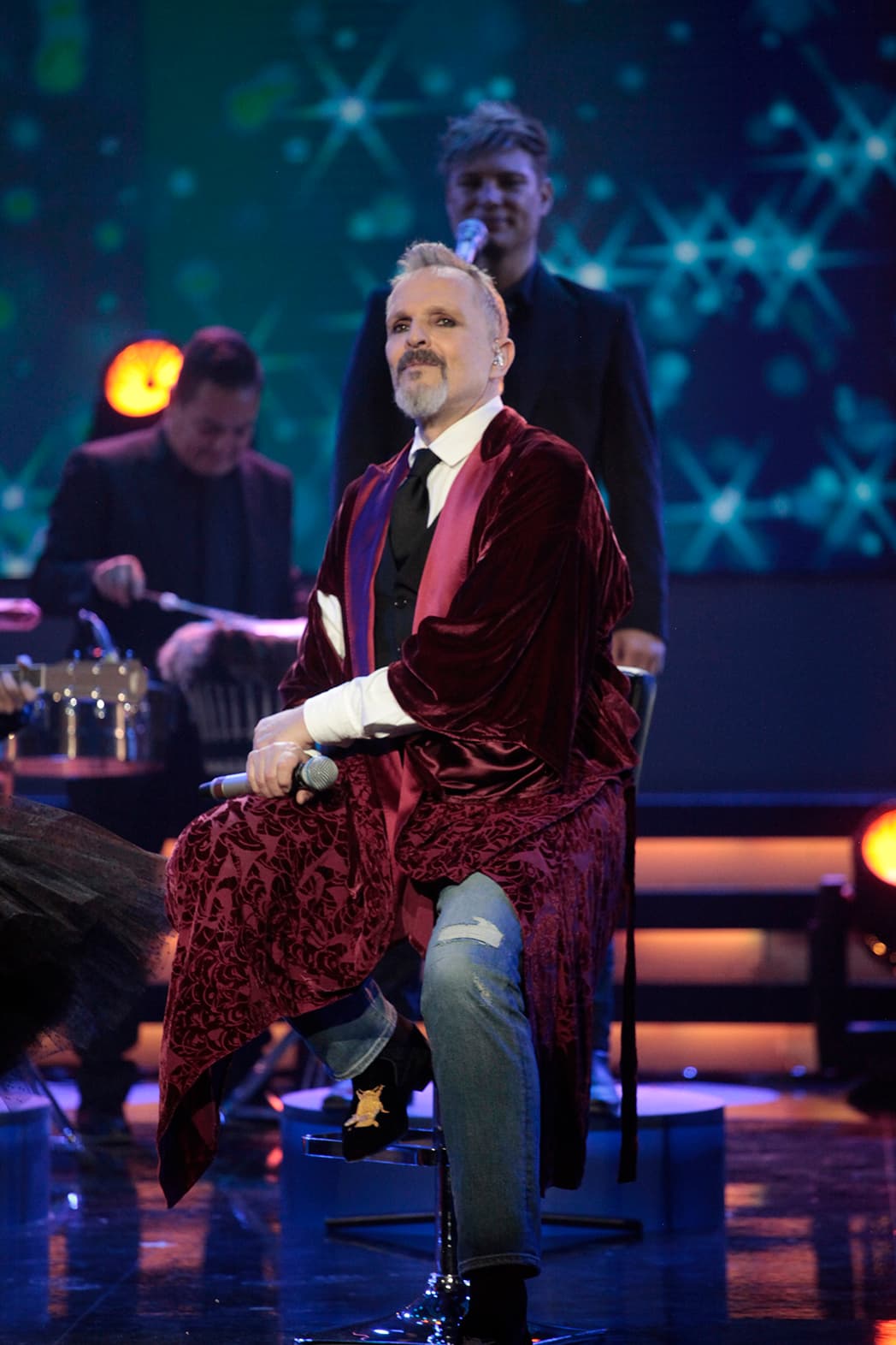 Jeans, camisa blanca, corbata y una norme y larga gabardina roja de tercipelo completaron el atuendo.