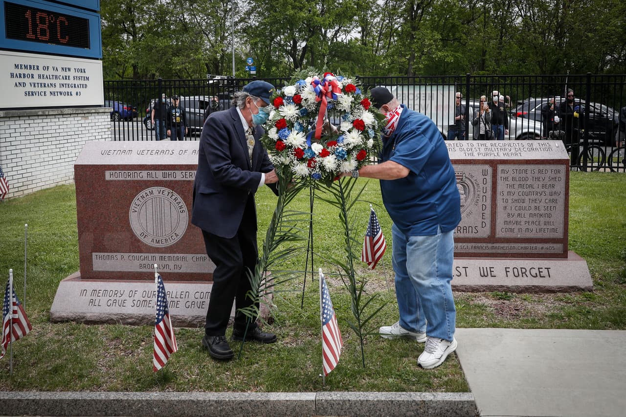 Las comunidades honraron a los caídos de la nación con ceremonias más pequeñas y moderadas que también recordaban a los perdidos por el covid-19. Una caravana de veteranos se detiene frente al VA Medical Center mientras se colocan coronas de flores junto a las piedras conmemorativas en las instalaciones, el lunes 25 de mayo de 2020, en el distrito de Brooklyn de Nueva York.