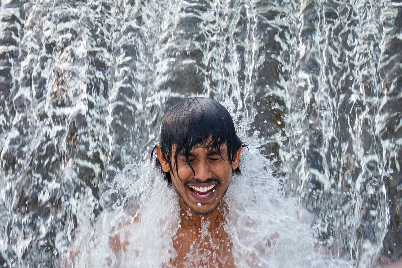 Un trabajador migrante de Sri Lanka se refresca en un río caudaloso en un día de calor sofocante, en las afueras de Bragadiru, Rumania, el martes 18 de agosto de 2026. (Foto AP/Andreea Alexandru)
