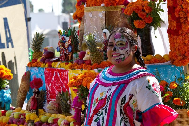 Una mujer posa junto a su altar en el cementerio Hollywood Forever