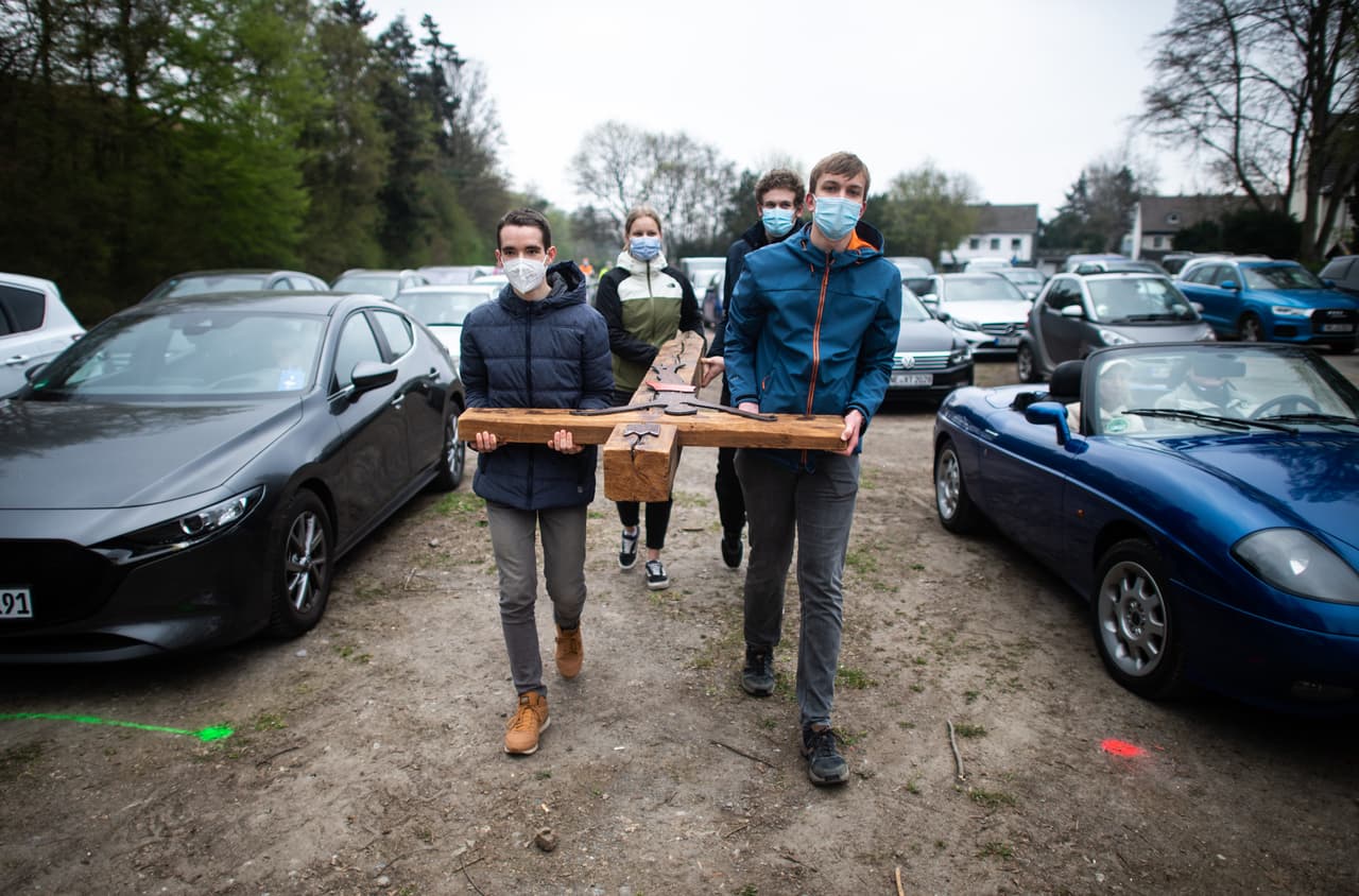 Un grupo de jóvenes lleva una cruz de madera durante una ceremonia religiosa en autos, realizada en Neuss, Alemania. El 
<a href="https://elordenmundial.com/mapas/cristianismo-en-el-mundo/"><u>resto de los cristianos</u></a> lo ocupan los grupos ortodoxos (unos 300 millones) y otras religiones más pequeñas (unos 425 millones).