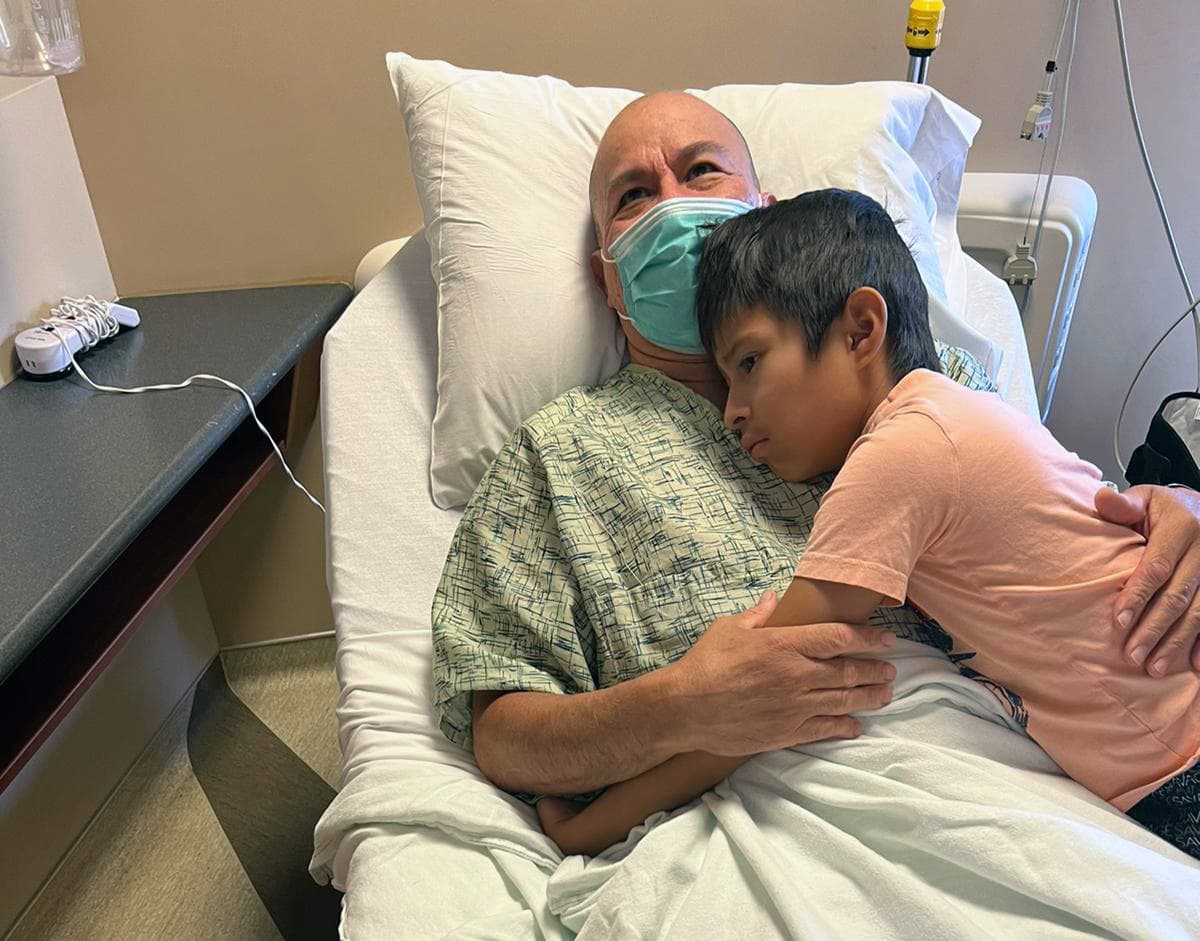 El pequeño hijo de ocho años de Felipe de Jesús Díaz lo abraza en el hospital.