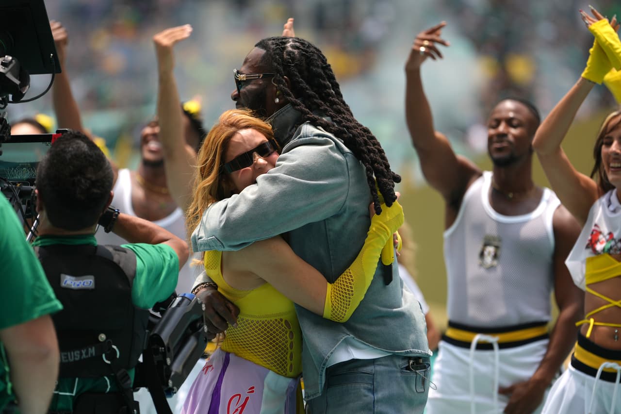 Shakira y Burna Boy se abrazan durante la ceremonia de inauguración previa al partido de fútbol del Grupo A de la Copa del Mundo entre México y Sudáfrica, en Ciudad de México.