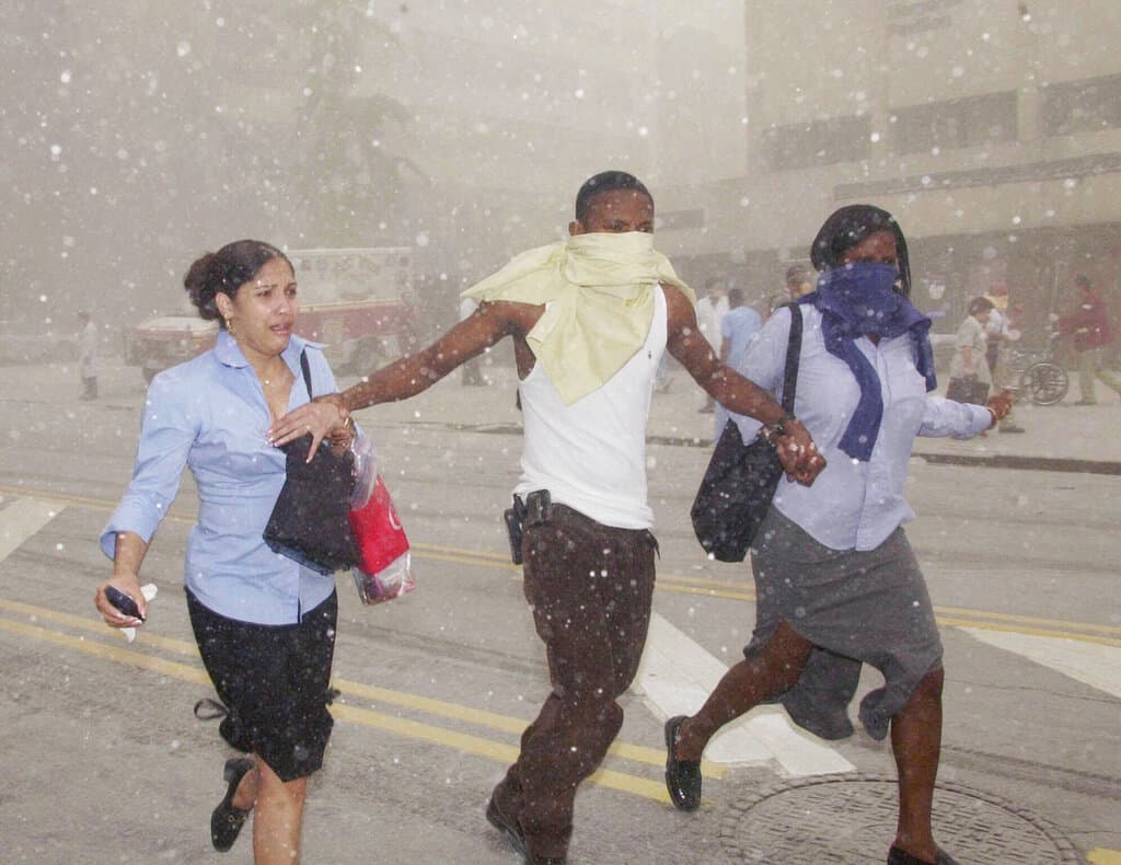 Tres trabajadores se abren paso a través del polvo durante la crisis en el sur de Manhattan.