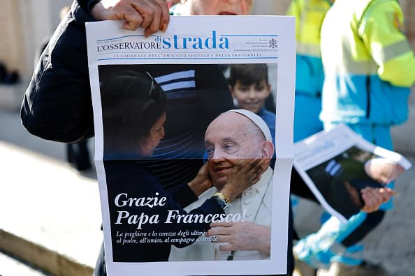 Un hombre muestra la portada de un periódico local cuya apertura se titula "Gracias, papa Francisco".