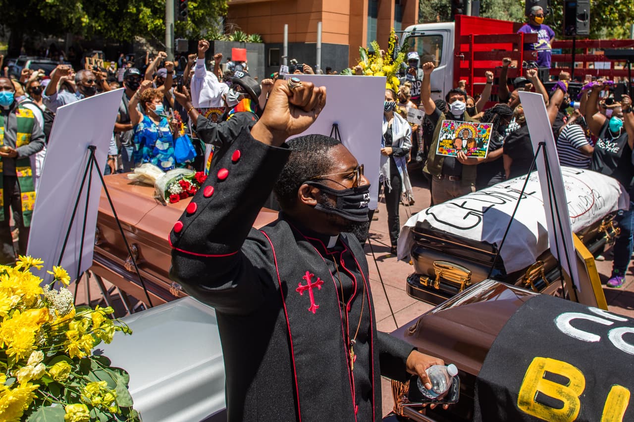 El clérigo Eddy Anderson protesta frente a los ataúdes durante una simbólica procesión fúnebre en Los Ángeles, California, en la cual participaron cerca de mil personas.