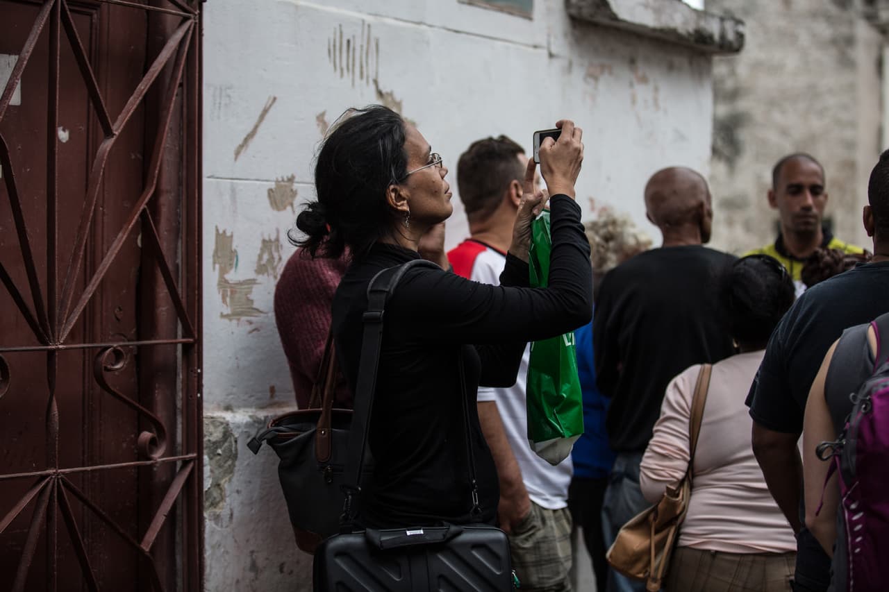 Luz Escobar de 14yMedio se confunde con la gente que espera a Obama para tratar de tomar fotografías con su celular.