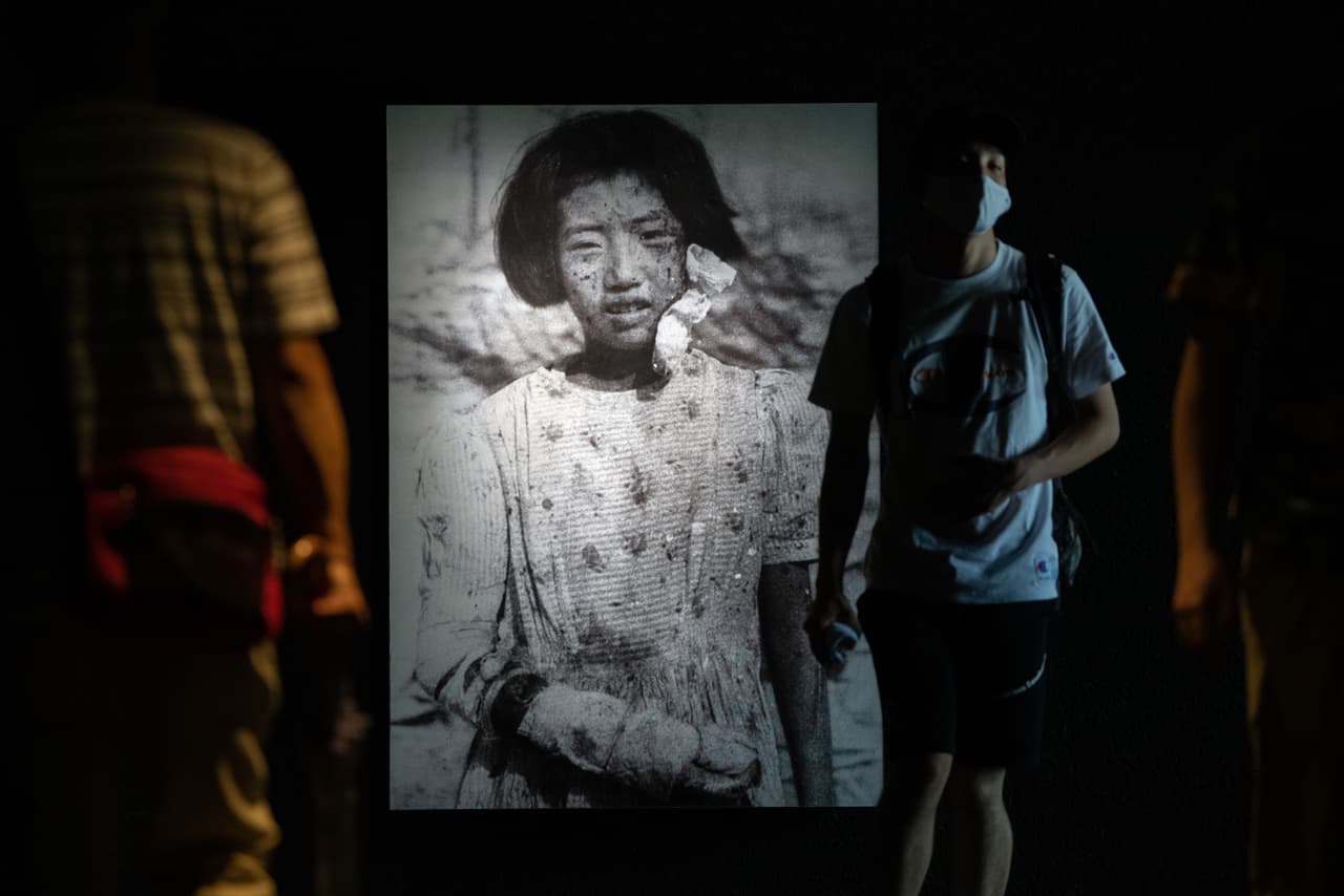 En el Museo Conmemorativo de la Paz de Hiroshima, los visitantes pasan junto a una fotografía de Yukiko Fujii, sobreviviente de la bomba atómica de 10 años, que tuvo dos hijos pero murió de
<a href="https://www.univision.com/temas/horoscopos-cancer">cáncer</a> a la edad de 42 años.