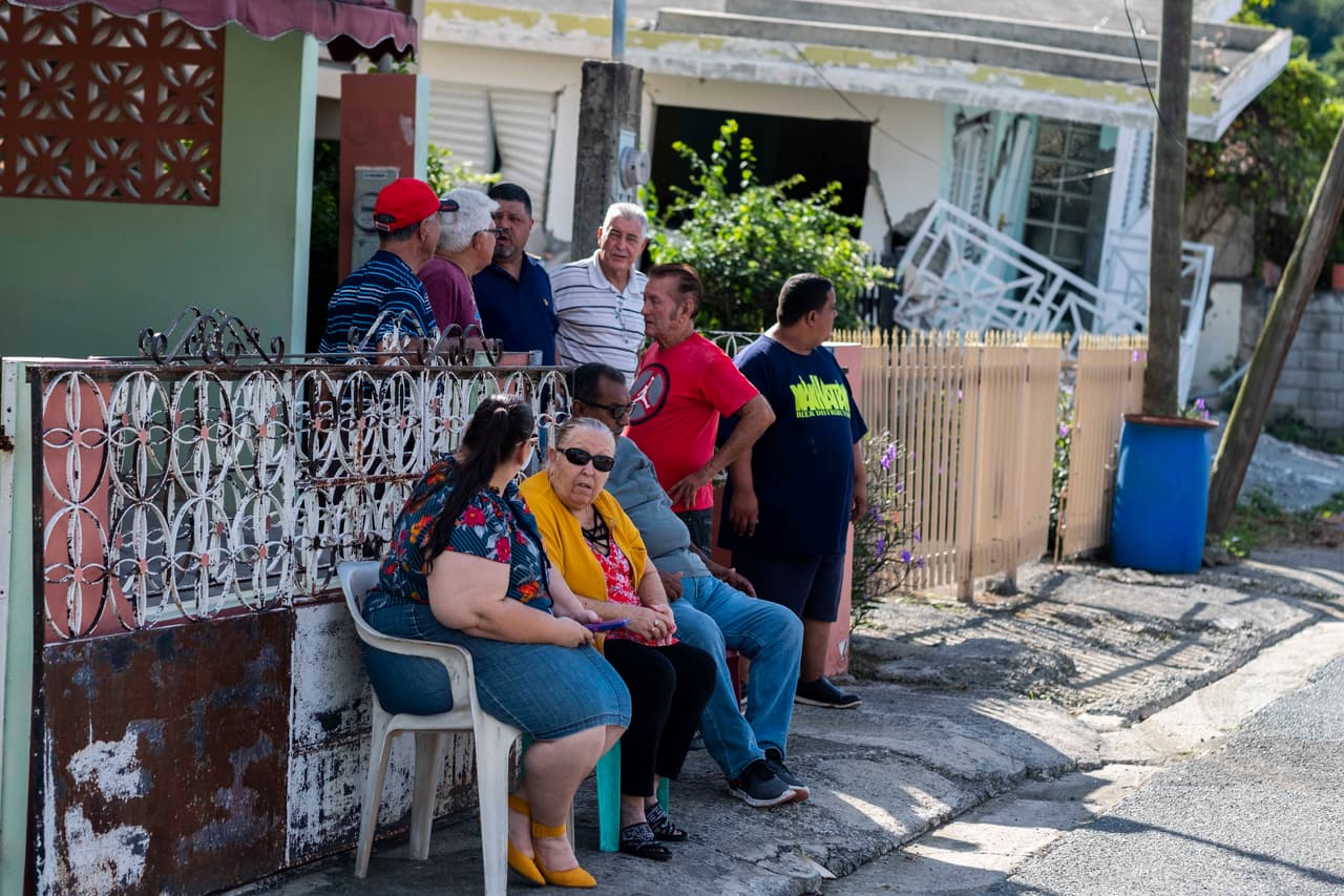 Algunos vecinos esperan fuera de las casa afectadas por el sismo al sur de Puerto Rico. No se reportaron víctimas y las autoridades descartaron el peligro de tsunami.