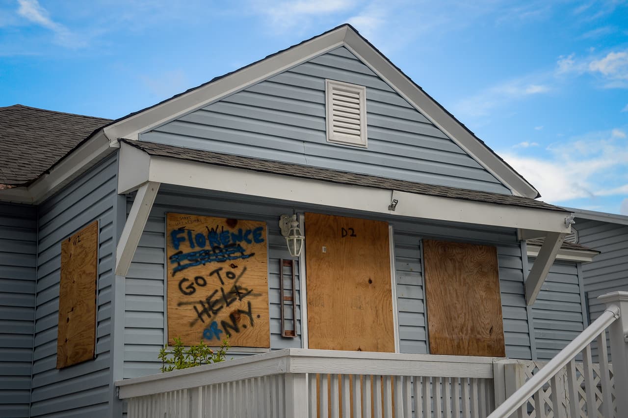 Cientos de casas han sido protegidas con paneles de madera en Carolina Beach, Carolina del Norte. “Florence, vete a Nueva York”, fue escrito en inglés una de las protecciones.