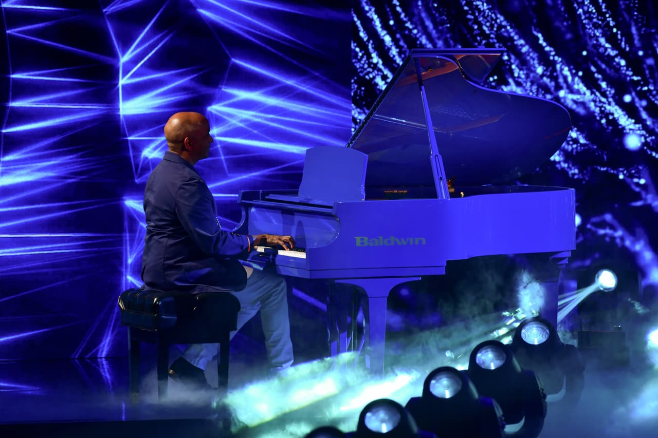 ¡Sergio George está en la casa! El productor musical impactó a todos al ocupar un asiento frente al piano que se colocó en el escenario de Reina de la Canción. El músico acompañó a Joss Favela durante su performance; el primero de este show de duelos.