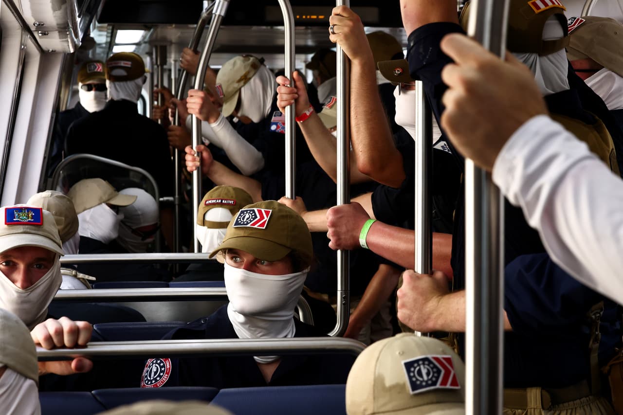 Con los rostros cubiertos por máscaras blancas, los hombres portaban banderas —algunas boca abajo, otras confederadas— mientras coreaban distitas consignas.