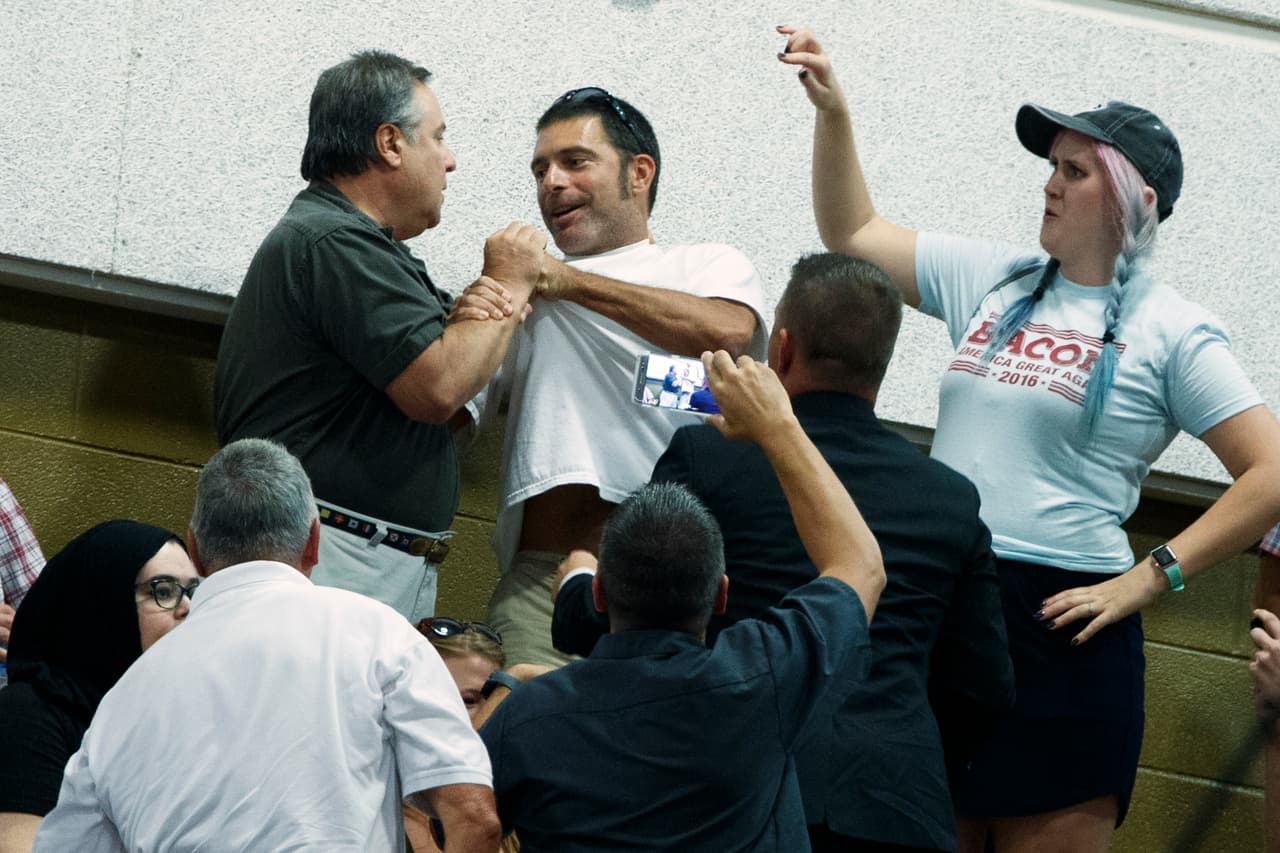 Un seguidor de Donald Trump ataca a un hombre que protesta en un mitin del candidato republicano a la Casa Blanca en Asheville, Carolina del Norte.