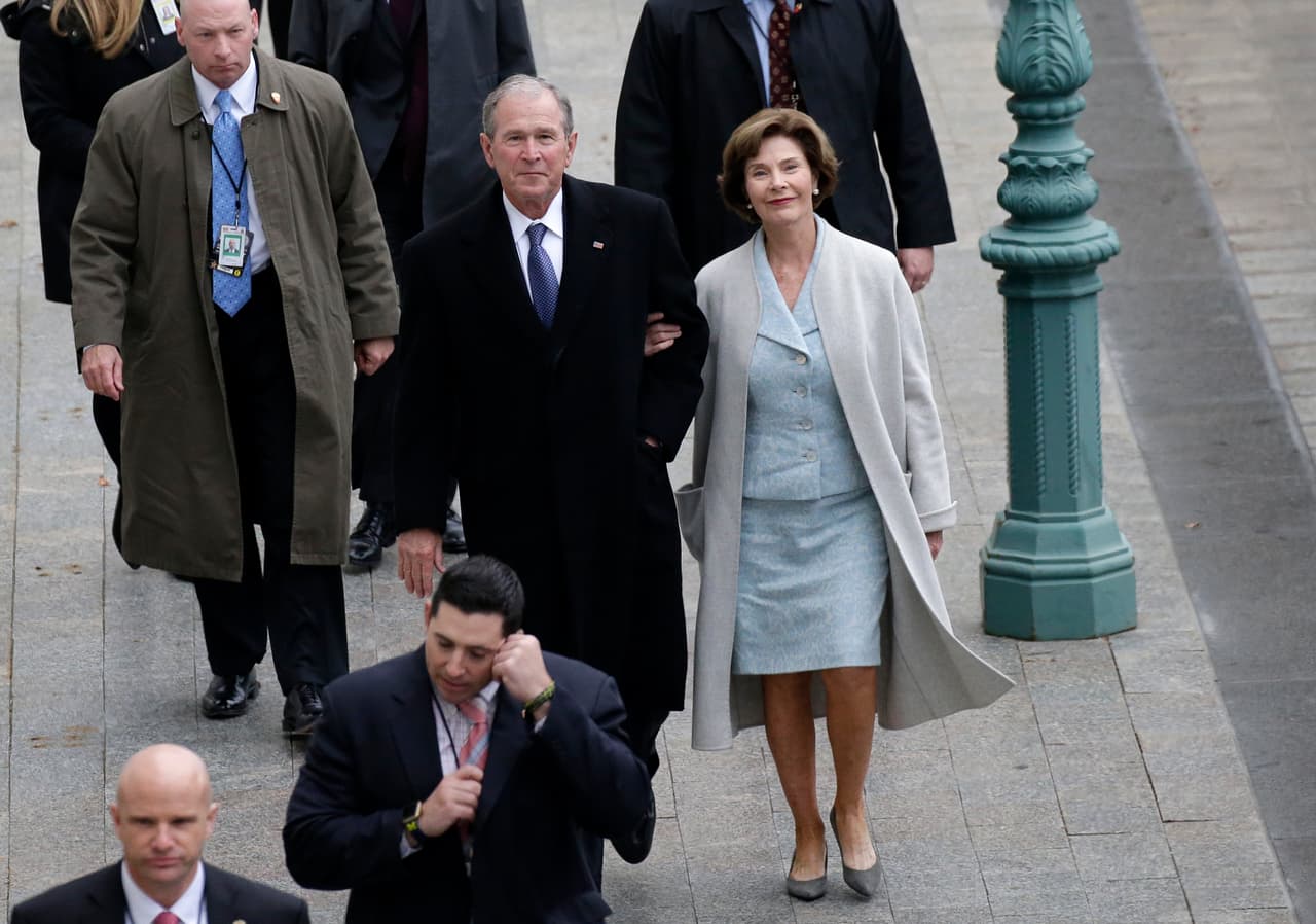 Laura Bush, esposa del presidente George W. Bush, eligió un traje sastre de
<i>mini print</i> floral también en tonos pasteles que acompañó con
<i>kitten heels </i>grises y un largo abrigo color hielo.