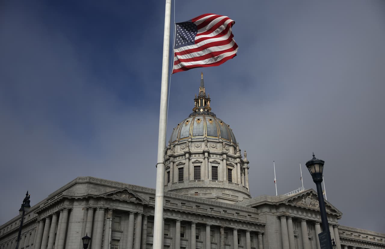 Una bandera estadounidense ondea a media asta frente al Ayuntamiento de San Francisco en San Francisco, California.