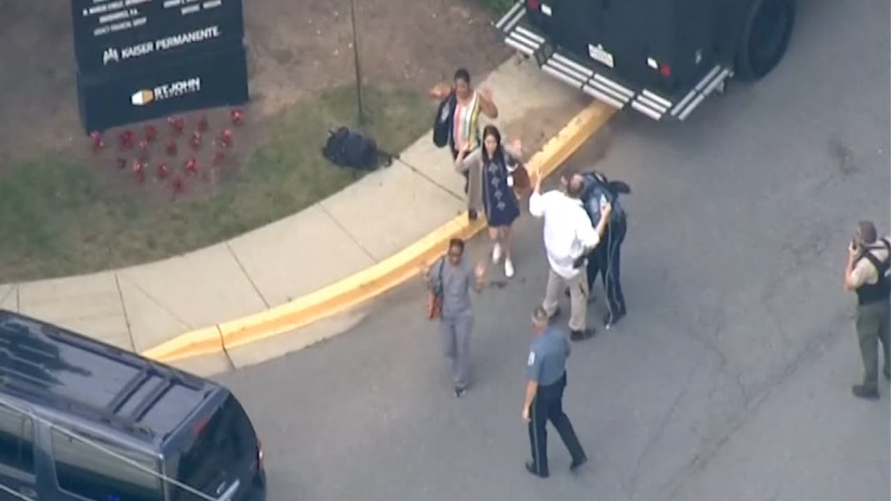 Uno de los empleados que sale del edificio es registrado por la policía al salir del edificio.