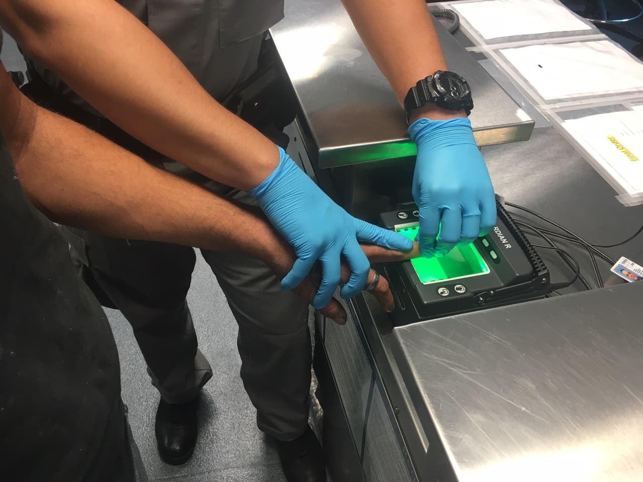 Toma de huellas digitales de uno de los inmigrantes bajo custodia.