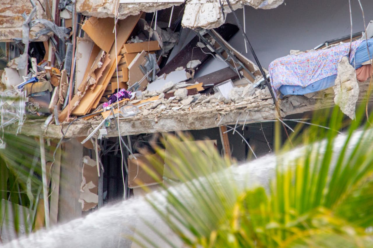 Un grueso chorro de agua se interpuso entre los curiosos y las ruinas del edificio. Por alguna razón las autoridades mantienen húmeda la zona y la lluvia que cae a ratos parece no ser suficiente para lo que necesitan.