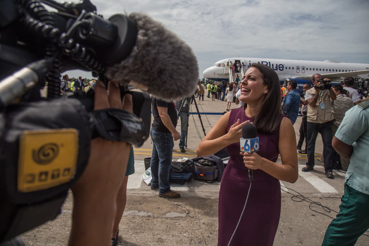 La periodista de NBC Amanda Plasencia se muestra conmovida mientras relata frente a cámaras, sobre la pista del aeropuerto de Santa Clara en Cuba. La emoción fue una constante entre la mayoría de comunicadores que cubrieron el evento, y muchos de ellos lo expresaron abiertamente ante sus cámaras y en sus reportajes.