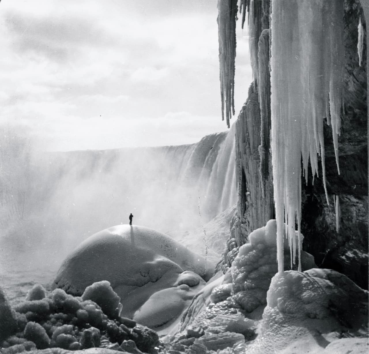 Antes de 1964 el hielo podía bloquear el flujo de agua río arriba, reduciendo el volumen de agua en el lado estadounidense de las cataratas hasta el punto de congelación. Esto sucedió cinco veces antes de que se agregaran barreras de de acero para evitar la acumulación de hielo. En la fotografía un hombre sobre el hielo bajo las cascadas congeladas, aproximadamente en 1903.
