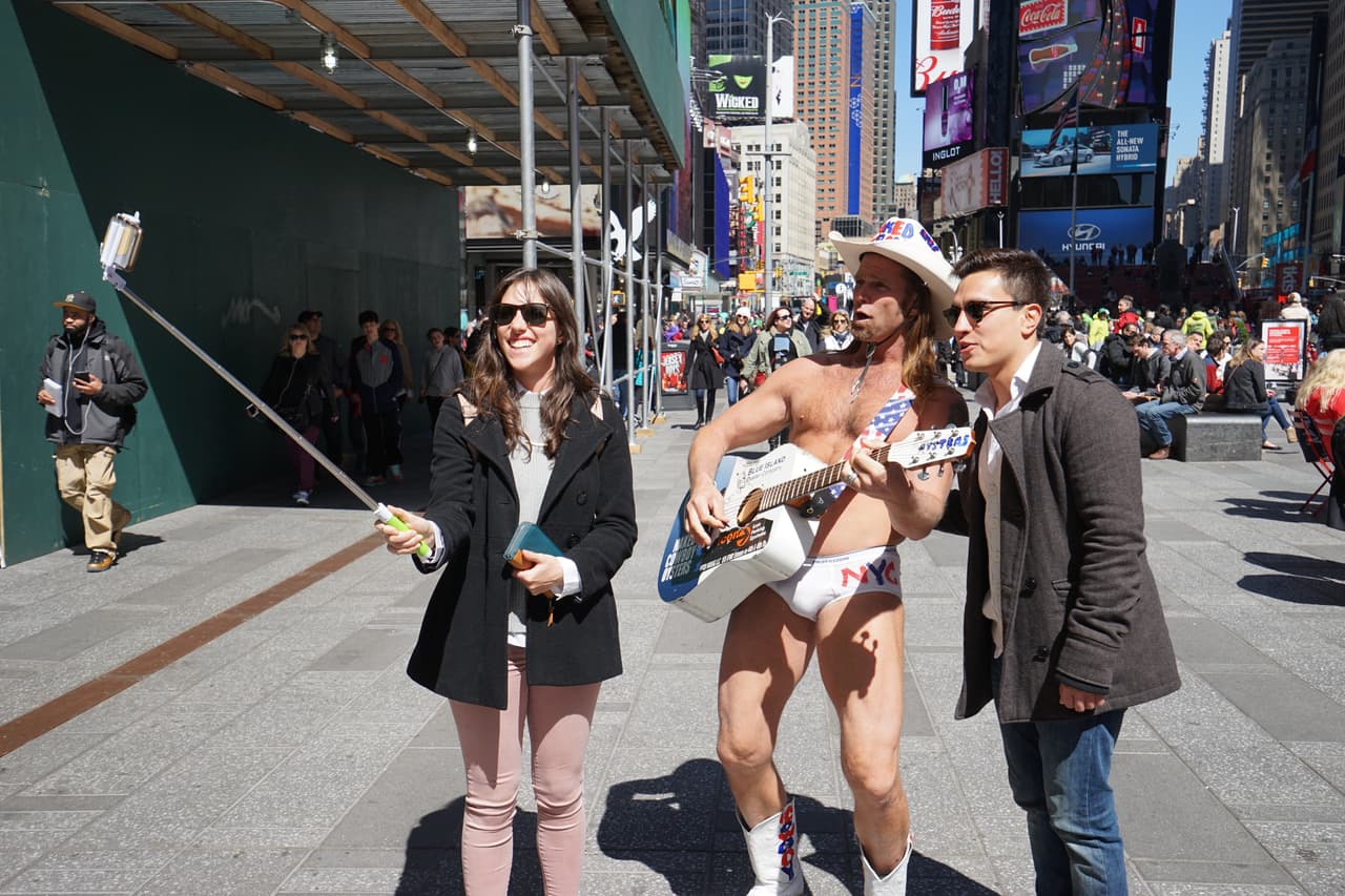 Turistas posan con el "Vaquero Desnudo" luego de que testificara en la aundiencia.