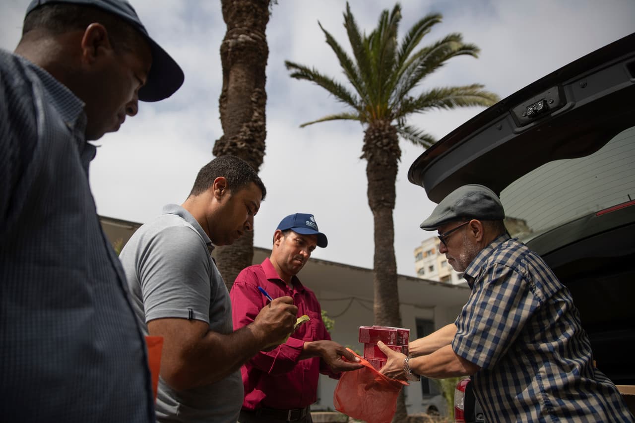 En la imagen se muestra a Habib El Ghazaoui, a la derecha, un padre que dirige la Asociación para la Solidaridad con los Niños de la Luna, distribuye crema a los padres de niños afectados por un trastorno raro llamado xeroderma pigmentoso, o XP, dentro de un Hospital en Casablanca, Marruecos.