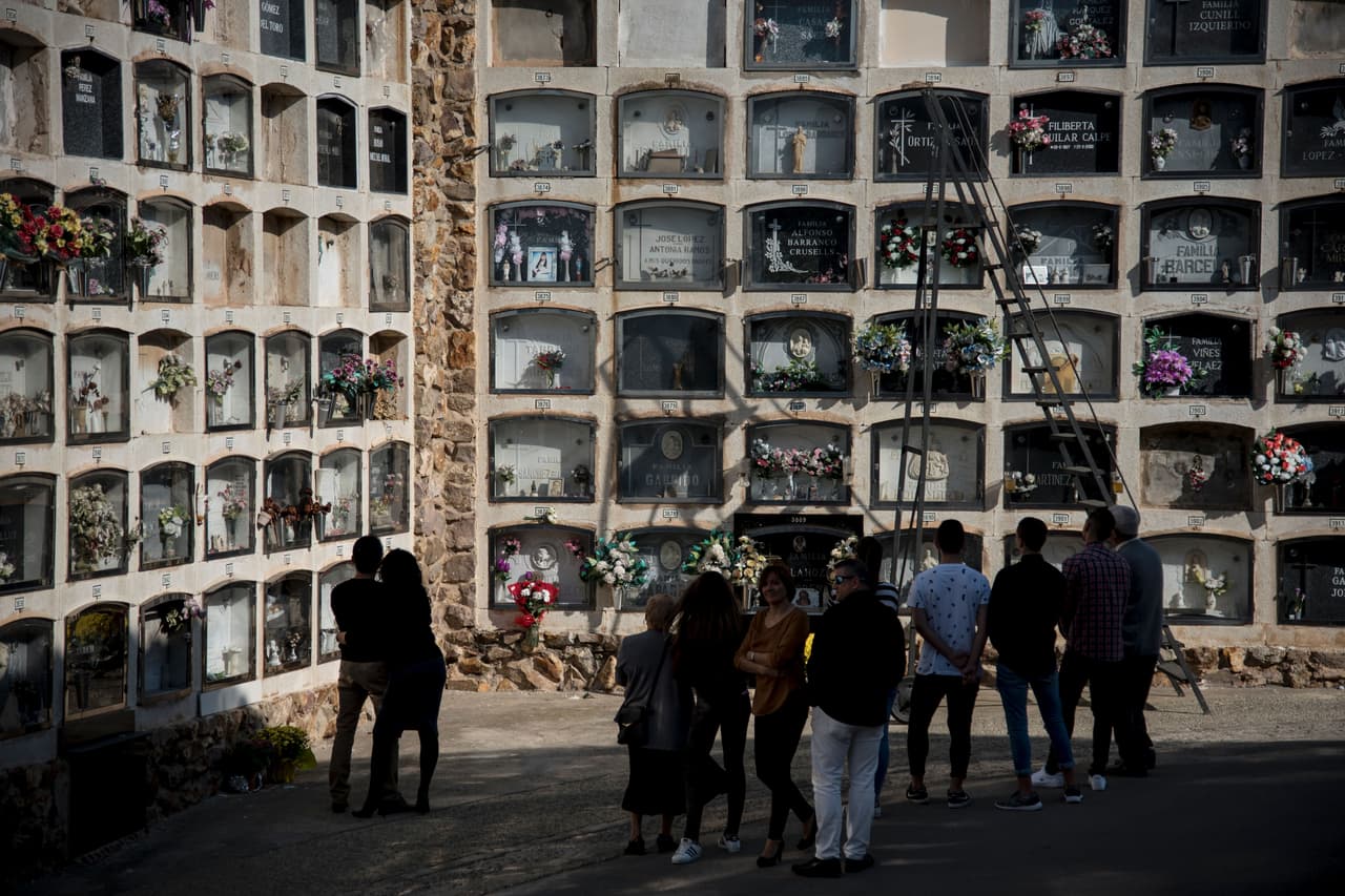 <b>España.</b> Varias familias se congregan junto a las tumbas de un cementerio en Barcelona.