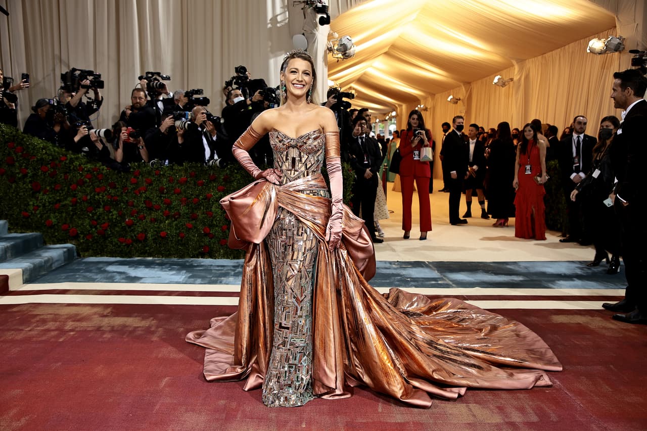 <b>Blake Lively</b> ya se ha posicionado como una de las favoritas de este evento en su rol como co-presidenta de esta edición, no podía decepcionar. En esta edición, su vestido fue doble y corrió a cargo de Versace. En un primer momento, parecía ser de un dorado rosado con un gran moño en la parte trasera.