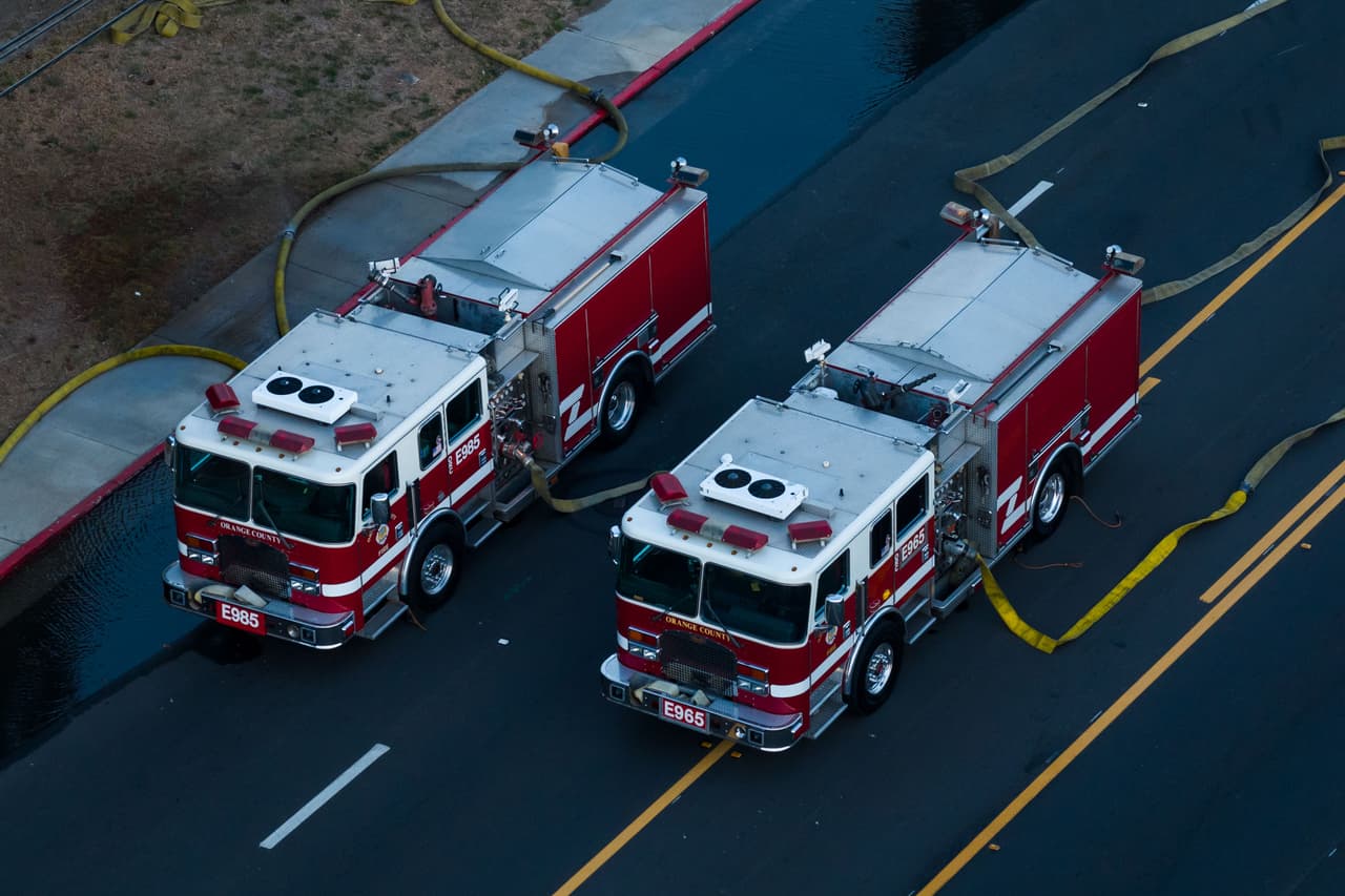 Camiones de bomberos bombean agua a un tanque de productos químicos que se sobrecalentó en una planta aeroespacial en Garden Grove, California, el viernes 22 de mayo de 2026. (Foto AP/Ethan Swope)