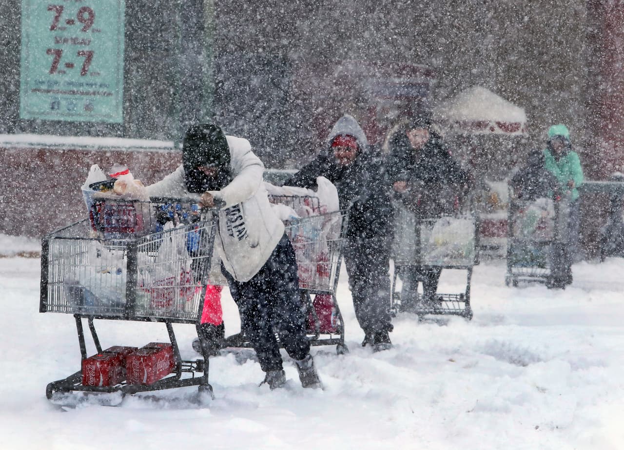 Una fila de compradores se desplazan bajo la tormenta en Boston, Massachusetts.