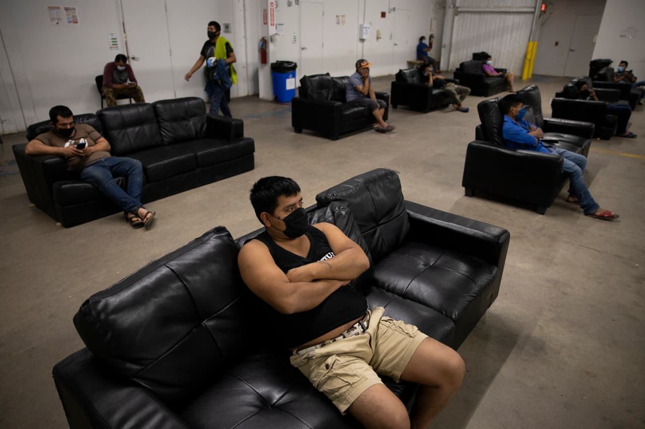 Inmigrantes que trabajan en la agricultura ven televisión con distanciamiento físico en King City, California.
<br>