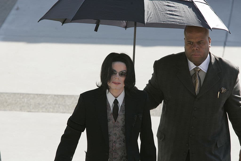 SANTA MARIA, UNITED STATES: Michael Jackson(L) arrives at the start of another week in his child molestation trial at the Santa Barbara County Superior Court on 07 March, 2005 in Santa Maria, California. AFP PHOTO/POOL/Kimberly White (Photo credit should read KIMBERLY WHITE/AFP via Getty Images)
