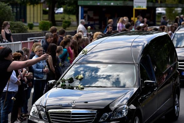 Los estudiantes de la escuela secundaria Joseph-Koenig-Gymnasium esperan el paso de las carrozas fúnebres.