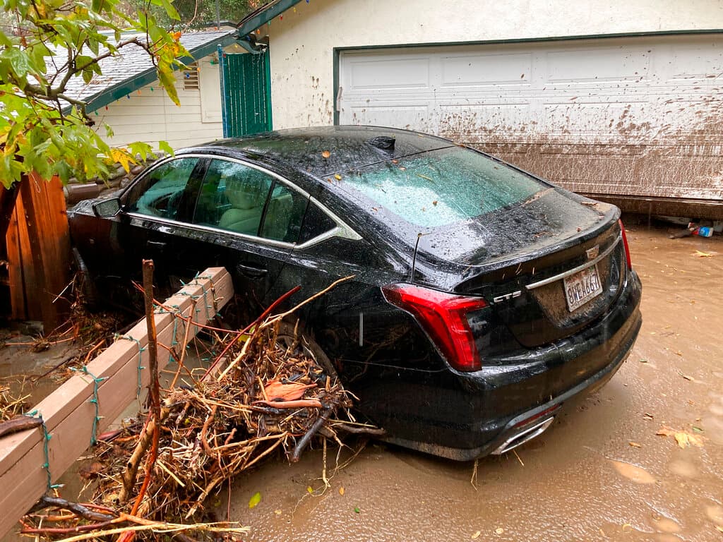 Este Cadillac CTS fue arrastrado por la corriente en el Cañón de Silverado, California. Más de 4.6 pulgadas (11.8 centímetros) de lluvia cayeron en 24 horas en el condado de Orange, al sur de Los Ángeles, donde los agentes del sheriff rescataron a los residentes después de que el barro inundara las casas de la zona afectada por los incendios forestales. No se registraron heridos.