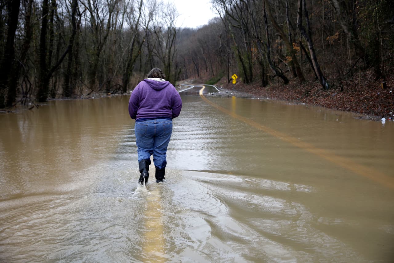 Tammy Poirrier camina por una calle inundada rumbo a su casa antes de ser evacuada