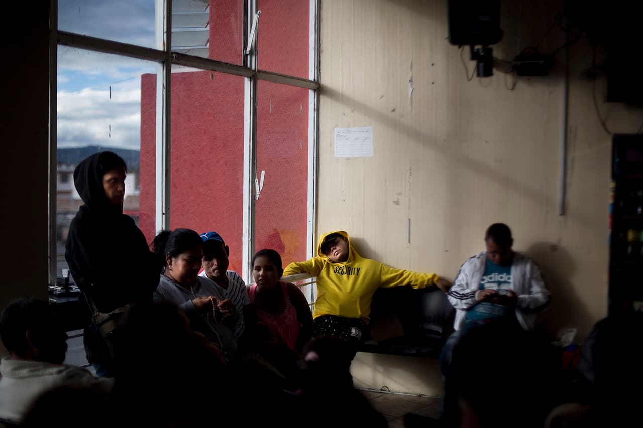 Migrantes venezolanos esperan, cansados, después de muchas horas, para cruzar la frontera, en la estación de buses de la ciudad ecuatoriana de Tulcán, donde emprenderán de nuevo su viaje al sur.