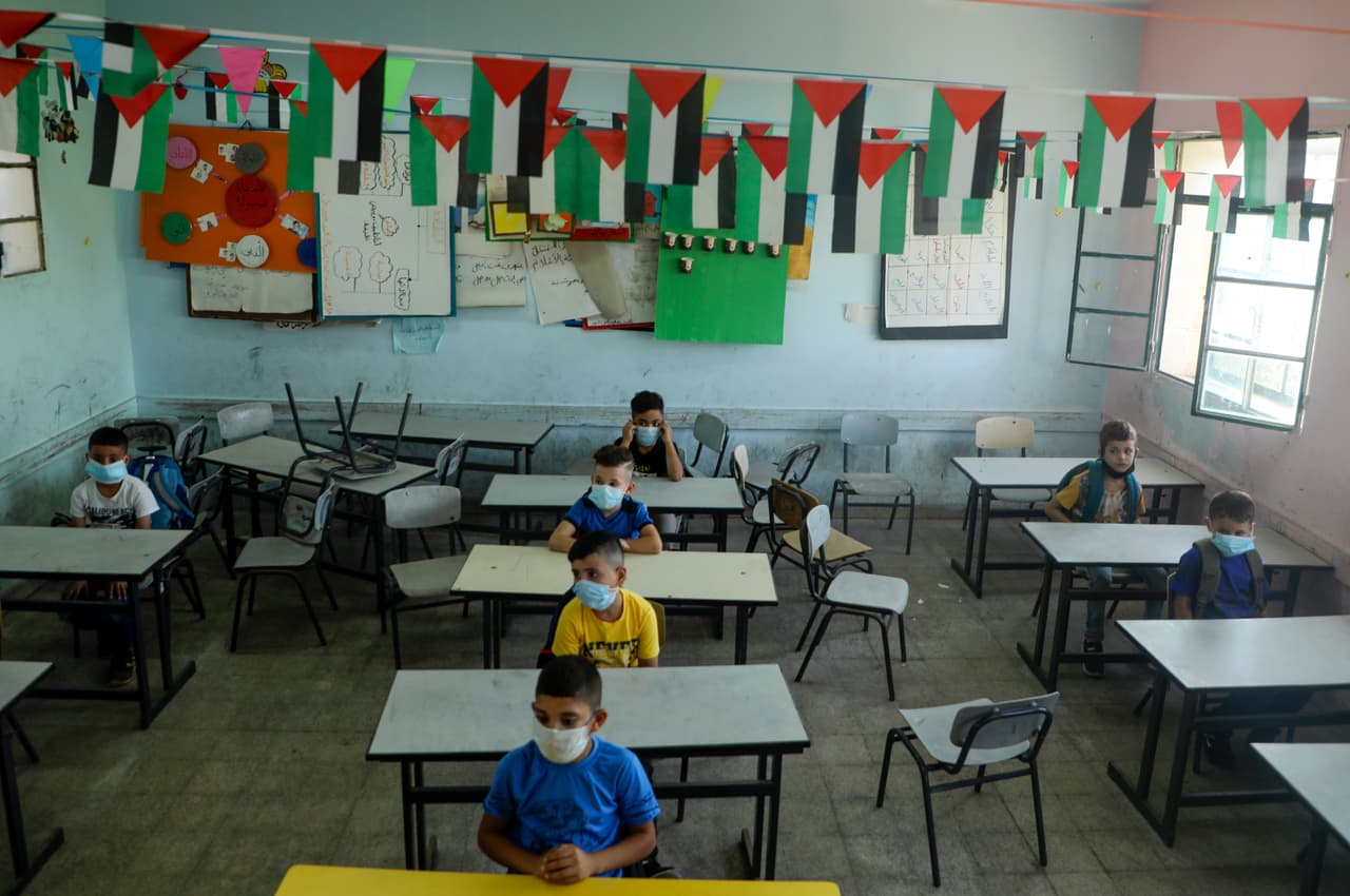 <b>Un negro panorama educativo |</b> El reporte estimó que la pandemia borrará el terreno avanzado en los pasados 20 años en materia educativa para las niñas, lo que resultará en más pobreza y desigualdad. "En 2020, más de 180 países cerraron temporalmente sus escuelas, dejando a 1,700 millones de niños y jóvenes fuera de las escuelas cuando esos cierres tuvieron su punto más álgido", dijo el reporte.
<br>
<br>"La pandemia ha privado a los niños en los países más pobres de cuatro meses de educación, comparado con las seis semanas en los países más ricos", agregó. En la foto, estudiantes palestinos con mascarillas en su salón de clases en Cisjordania.